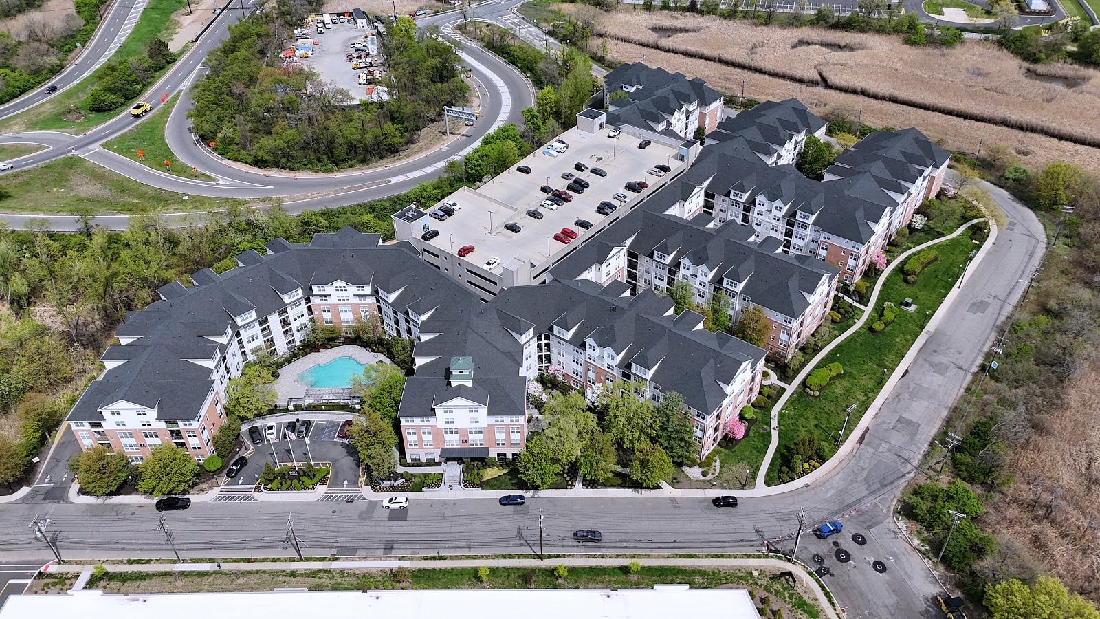 Aerial view of large apartment complex with dark shingle roofs